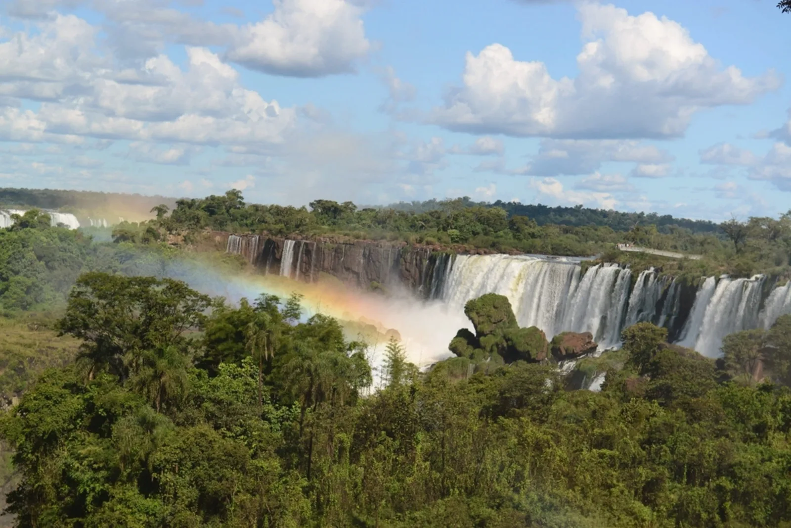 Parede de quedas das Cataratas do Iguaçu com um arco-íris na neblina